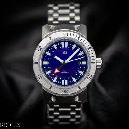 Hero shot of TS Munchen stainless steel GMT watch with blue dial on a dark background