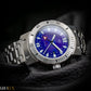 Pillow shot. Silver watch with a blue face on a dark background, featuring the brand 'Krolux'.